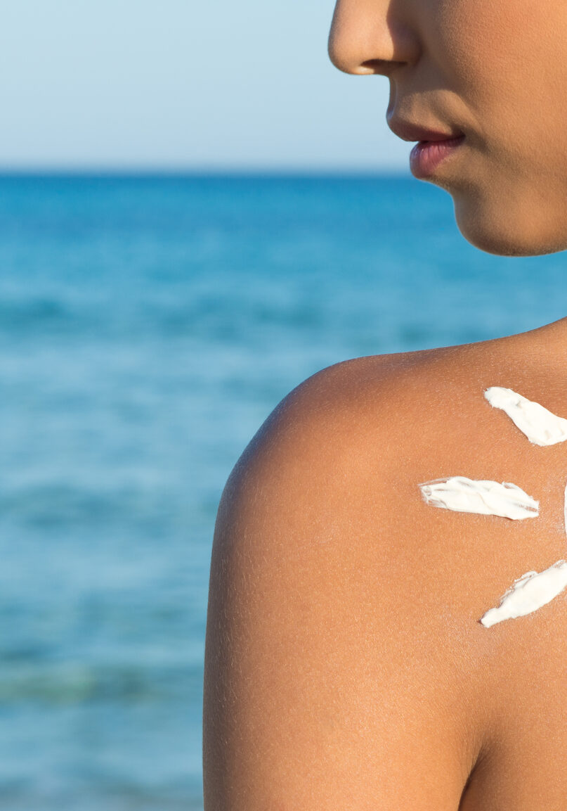 Woman With Suntan Lotion At The Beach In Form Of The Sun